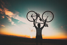 Cyclist Silhoutte With Bicycle Raised To Sky Race And Victory Concept