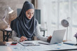 © Daenin - happy muslim business women in hijab at work smiling arab woman taking notes and work on laptop