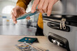 © Denys Kurbatov - Male tourist in airport using smartphone app to count money for trip