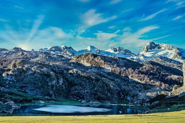 Wall Mural - Famous Covadonga lake surrounded by snowy mountains, mountain resort, touristic location of Asturias