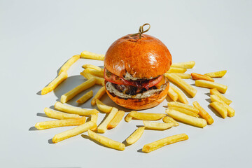 Wall Mural - Appetizing juicy burger and fries on light background. Hard light, deep shadow