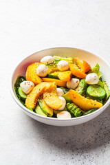 Wall Mural - Summer peach salad with avocado, cucumber and mozzarella. Healthy recipe, vegetarian food concept.