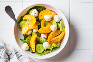 Canvas Print - Summer peach salad with avocado, cucumber and mozzarella. Healthy recipe, vegetarian food concept.