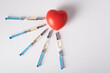 Five syringes with the medicine for injection lie next to a large red heart.