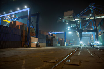 industrial port with containers. Stack of containers, gantry crane at night. Industrial Container yard for Logistic Import Export business.