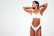 © halayalex - High fashion portrait of young beautiful sexy woman in white lingerie swimwear. Carefree model with perfect body. Hot tanned female isolated on grey in studio in summer swimsuit