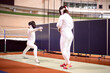 © Анастасия Гайкова - two fencers in white uniforms  are training to participate in a duel