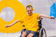 © unai - Disabled person in a wheelchair listening to music with headphones, dancing and smiling