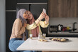 © Ladanifer - Two muslim women taking a selfie while having tea and arabic sweets at the kitchen table.
