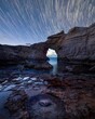 Long exposure shot of the star trails on a rocky beach