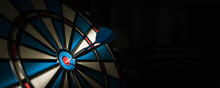 A Dart Hitting The Center Of Target With Copy Space In Dramatic Light And Shadow. Bullseye Target Or A Dart Dashboard For Financial Business Planning And Targeting With Winner Goal Concept
