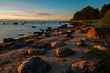 Sunrise on the beach with stones on coast.