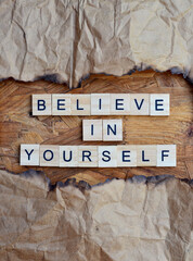believe in yourself text on wooden square, motivation quotes