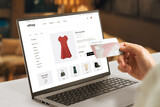 Fototapeta Nowy Jork - Shopping online with credit card concept. Modern e-commerce web page with woman clothes on laptop display