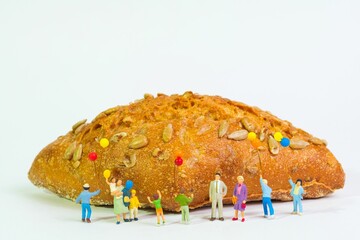 Poster - happy family with colorful balloons stands in front of a freshly baked crunchy grain bread,