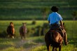 Back view of a gaucho riding a horse in the countryside