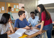 © gonzagon - Group of multi-ethnic students talking in class during a break. High school, back to school, diverse students