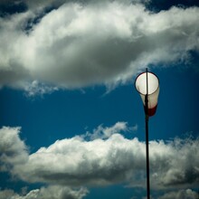 Closeup Of A Windsock Indicator Under The Blue Sky With Clouds