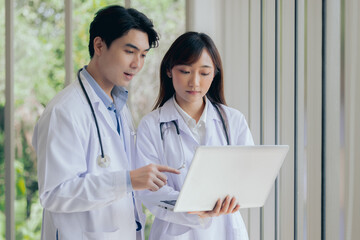 Asian two male female professional doctor using computer laptop checking patient's medical records ,Portrait doctor healthcare professionals