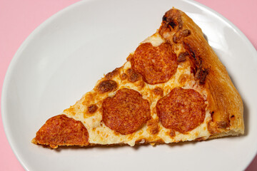 Wall Mural - Pizza slices on a plate on a pink background. Pizza with sausage. Fast food