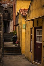 Vertical Shot Of A Passage Along Yellow Houses In Porto, Portugal