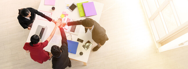 Banner cover design. Top view of business people clapping hands together over table, Below graphs placed on the desk. businessman and businesswoman stack of hands showing unity and teamwork support.