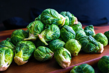 Wall Mural - Fresh Brussels Sprouts Piled on a Wood Cutting Board: A pile of Brussels sprouts viewed closeup from the side