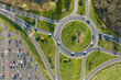 canvas print picture Aerial view of road roundabout intersection with moving heavy traffic. Urban circular transportation crossroads