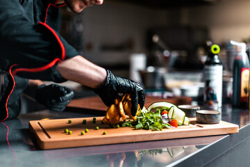 Chef serving food in the modern kitchen in a high-end restaurant