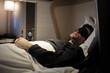 © StudioWout - Business man sleeping with sleeping mask at the first class of airplane in comfortable single bed