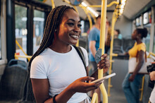 African American Woman Using Smartphone While Riding A Bus In The Night