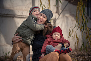 Wall Mural - Mamá con sus hijos bebé y niño disfrutando del otoño invierno entre los árboles