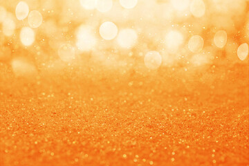 Wall Mural - Shiny orange glitter and blurred lights on background. Bokeh effect
