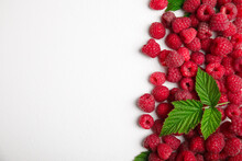 Fresh Ripe Raspberries With Green Leaves On White Background, Flat Lay. Space For Text