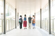 © sinseeho - Group of multi-racial college student friends walking together in hall. Rear view.