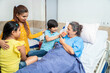 © GAJENDRRA BHATI  - Indian kid boy help senior old patient eat apple at hospital. Family visit at clinic. Old people health care concept.
