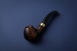Smoking pipe on blue background, close up