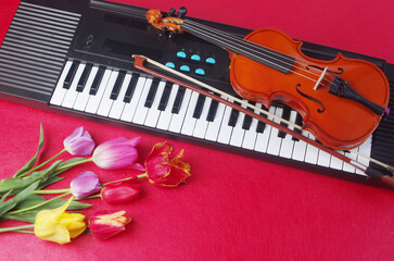 Wall Mural - A violin with a bow, a synthesizer keyboard, a bouquet of tulips, lilies of the valley and lilacs. 