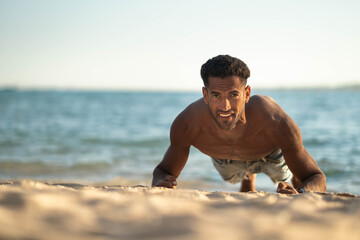 Handsome and confident, outdoor smiling portrait of relaxing young african egyptian man traveler on the beach.