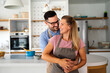 © NDABCREATIVITY - Attractive couple is cooking together organic healthy food in kitchen.