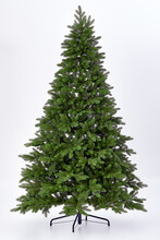 Artificial Christmas Green Tree Without Decorations On A Metal Stand Isolated On A White Background.