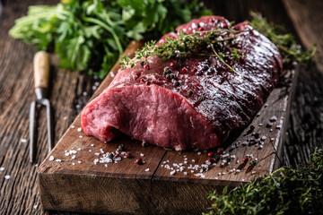 Wall Mural - High rib eye steak whole on a wooden board with herbs - Close up