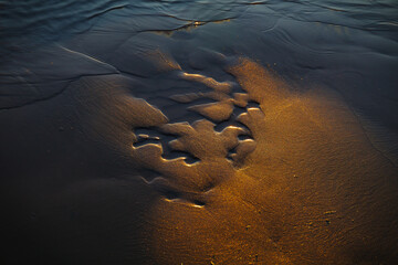 Wall Mural - Close up view of sand reflecting sunset.