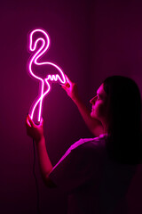 Wall Mural - Beautiful girl with neon signs. Pink neon flamingo. Trendy style. Neon sign. Custom neon. Home decor. 