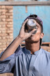 a thirsty laborer is drinking water at a construction site
