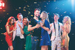 © Loginova - Party and celebration. Group of seven happy smiling friends having fun together among confetti in night club.