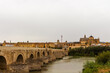 Cordoba, Spain, September 13, 2021: Guadalquivir River and the Roman Bridge, with Cordoba Mosque-Cathedral in the background.