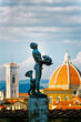 Bronze statue in the Boboli Gardens of the Palazzo Pitti Florence, Italy. Campanile and dome of the Duomo cathedral behind