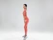 © halayalex - Tanned fitness woman in pink sports clothing. Sexy young beautiful model with perfect body.Female isolated on grey background in studio. Stretching out before training. Full length