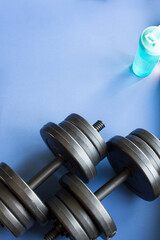 Set of dumbbells for training the whole body, copy space, blue background